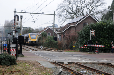 909548 Gezicht op de spoorwegovergang in de Burgemeester Reigerstraat te Utrecht, met de pendeltrein tussen het ...